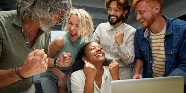 Colaboradores comemorando em frente ao computador 